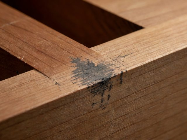 Pencil transfer marks on the inside shoulder of a wooden slot identifying one high contact point